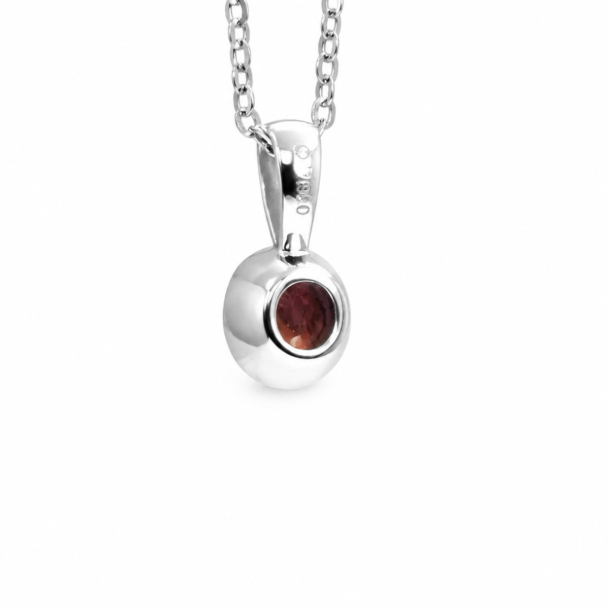 Bezel set unheated ruby pendant in platinum shown at an angle