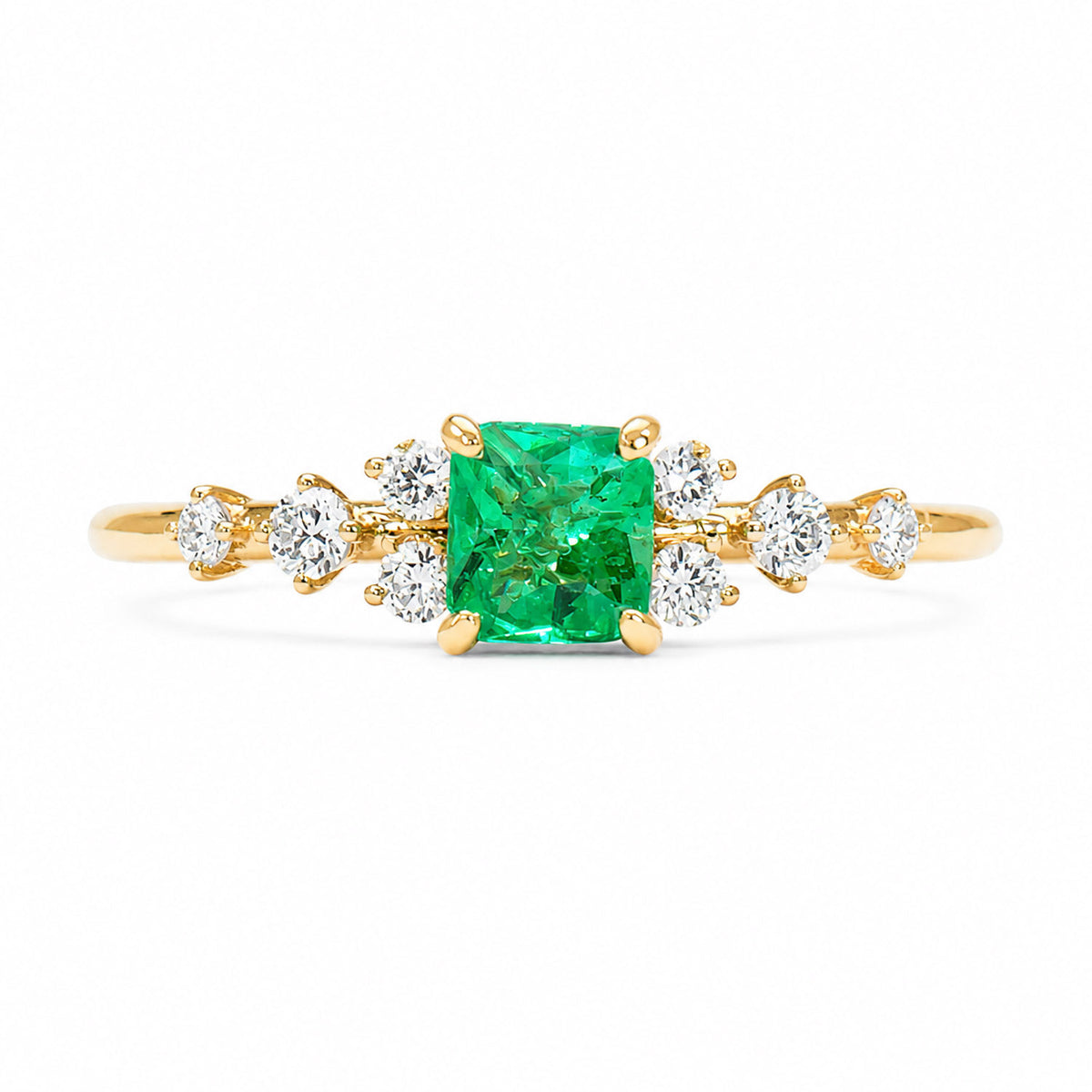A gold ring with a square cut Colombian emerald in the centre and accent round diamonds on the shank on a white background