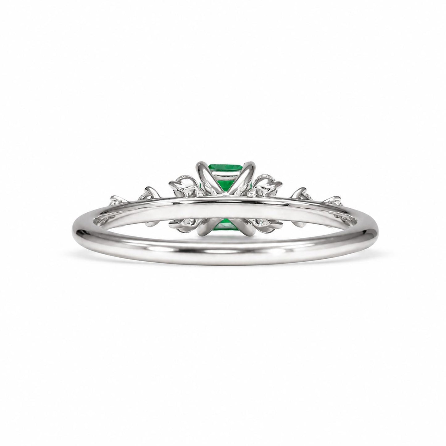Back view of a platinum ring featuring a central Colombian emerald gemstone and delicate side accent diamonds, shown on a plain white background.