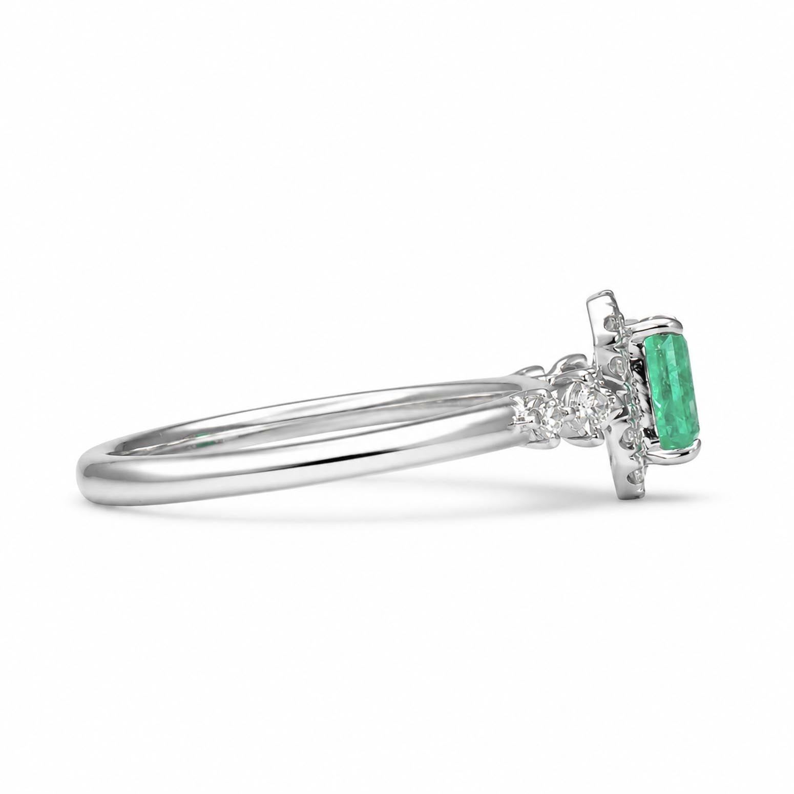 A platinum ring featuring a rectangular emerald-cut Colombian emerald and accent diamonds, shown in profile against a clean white background.