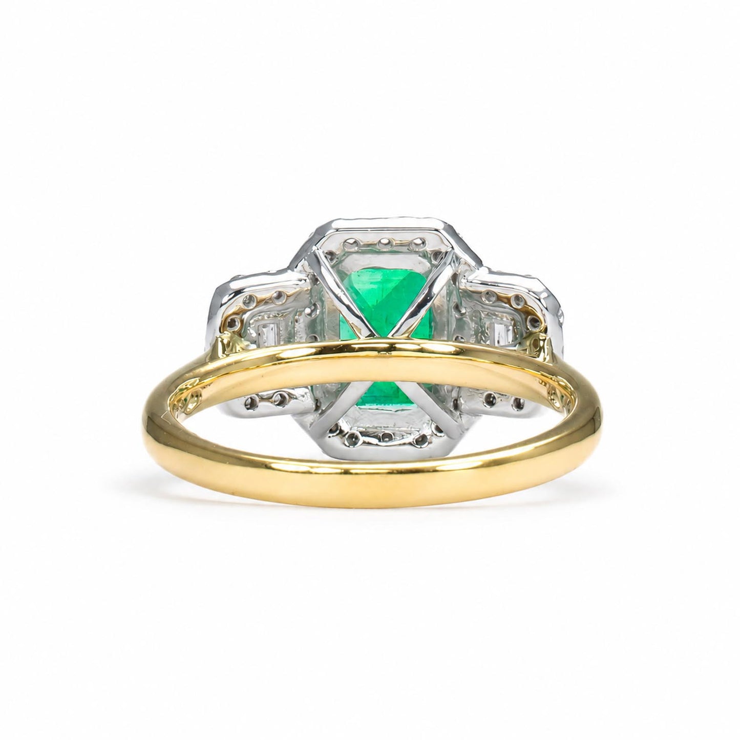 A yellow gold ring with a platinum setting featuring a central Colombian emerald and diamond accent stones, shown on a white background.