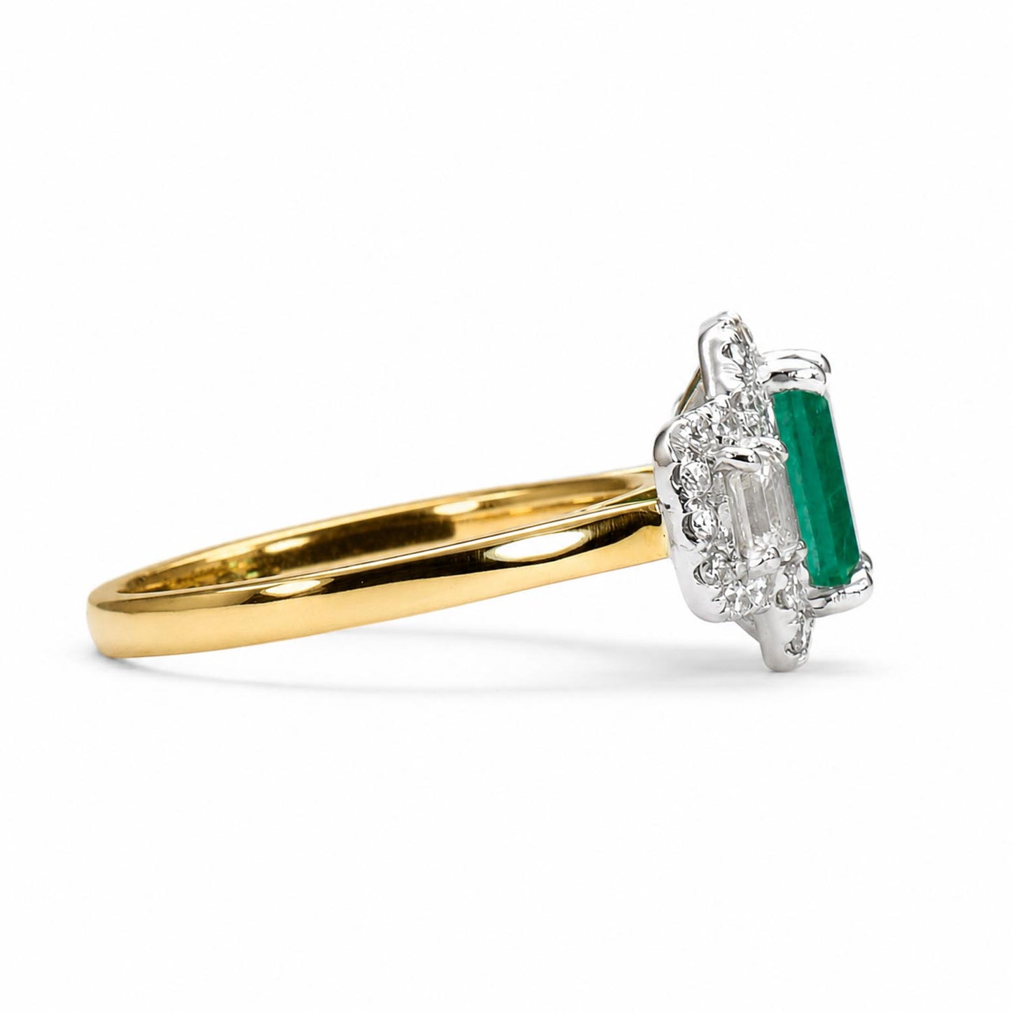 A yellow gold ring with a platinum halo setting featuring an elongated emerald-cut center stone and accent diamonds, shown on a clean white background.