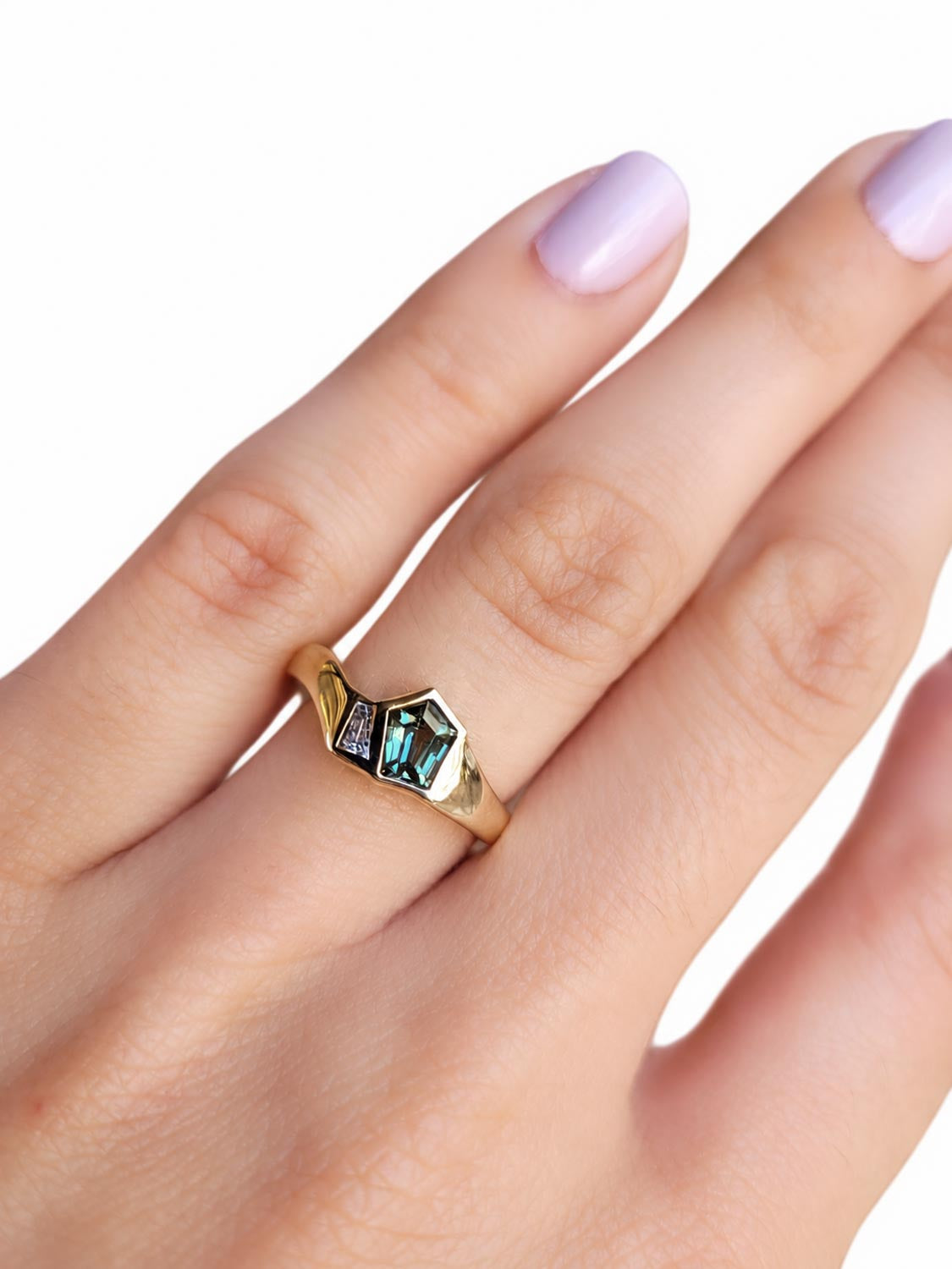 Close detail of the unique pentagonal teal sapphire centre stone