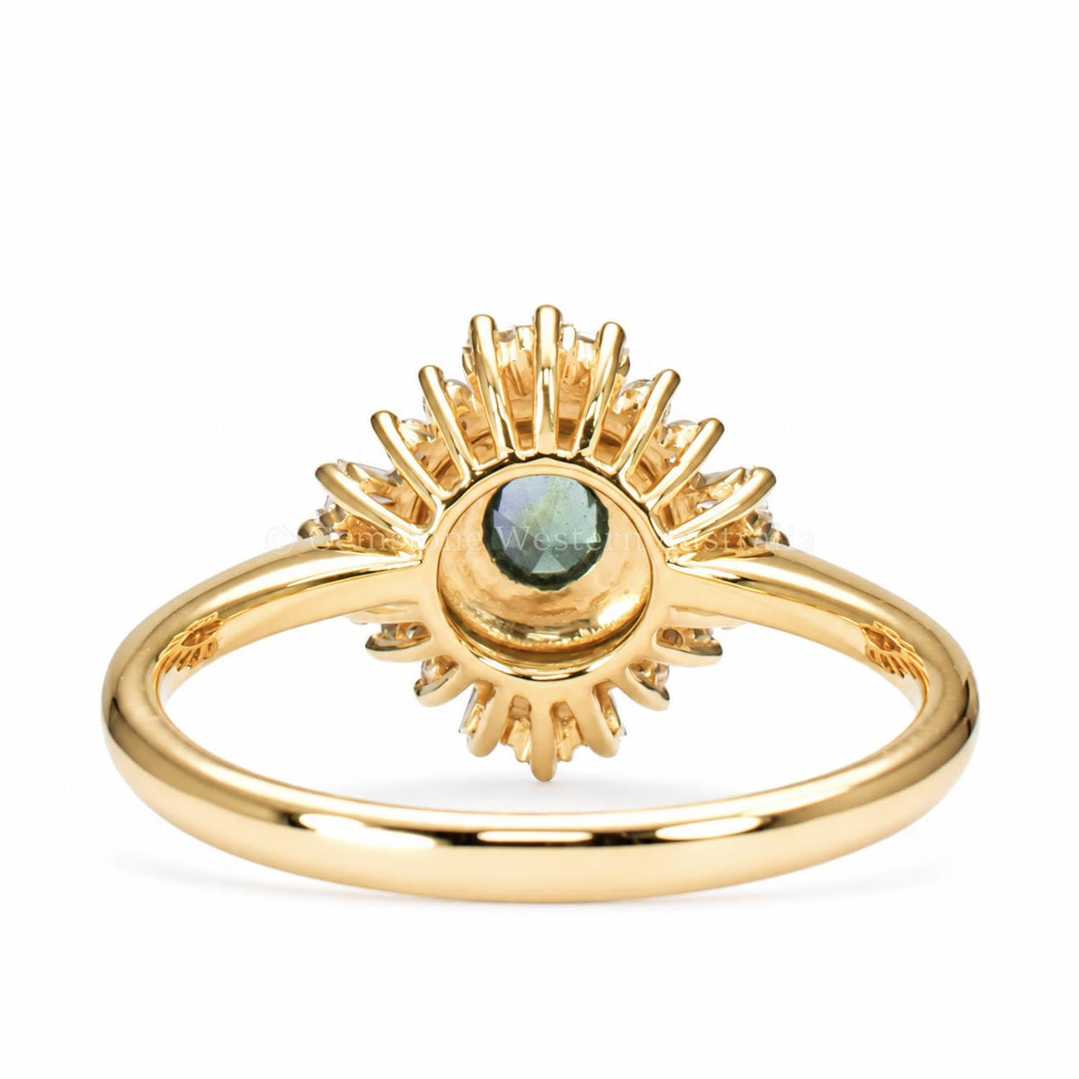 Close detail of the round teal sapphire bezel setting in 18K yellow gold