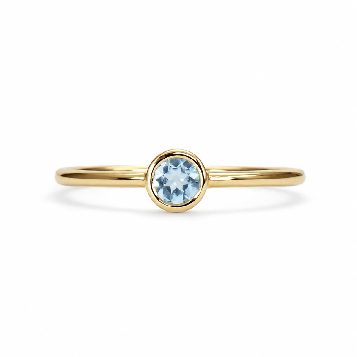 Dainty round aquamarine bezel ring in yellow gold