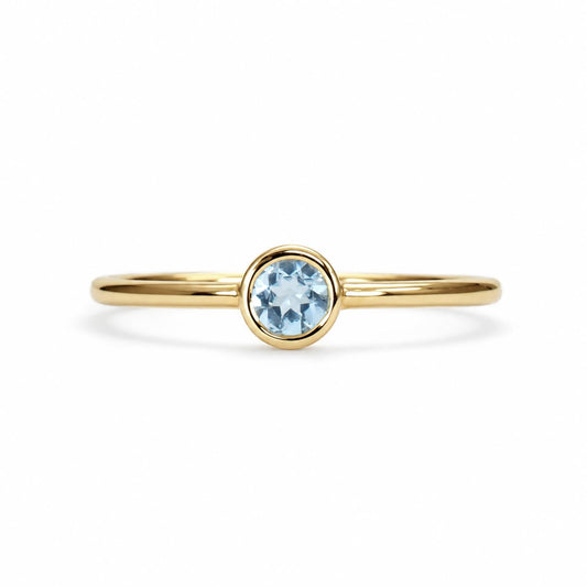 Dainty round aquamarine bezel ring in yellow gold