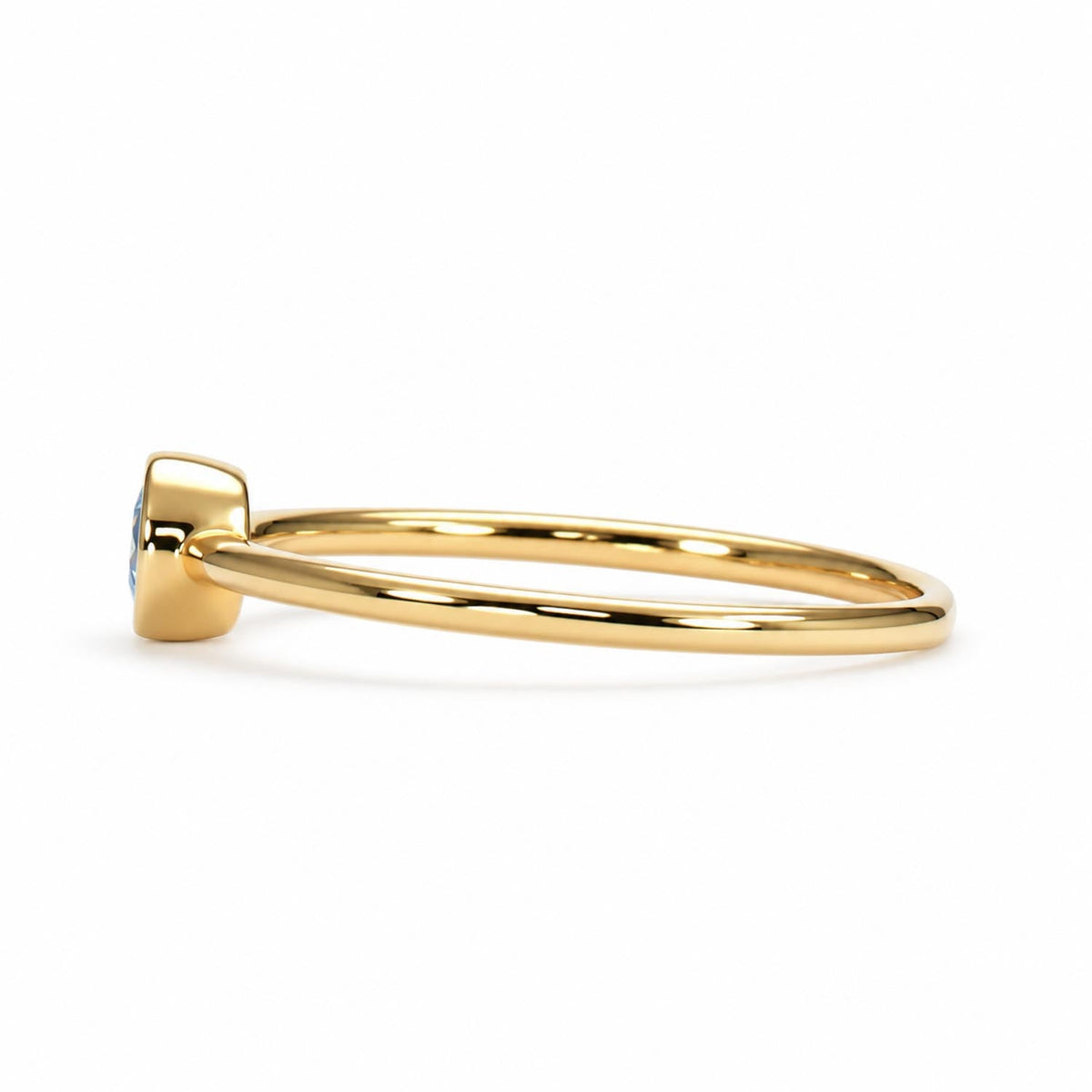 Bezel set round aquamarine ring in yellow gold shown at an angle