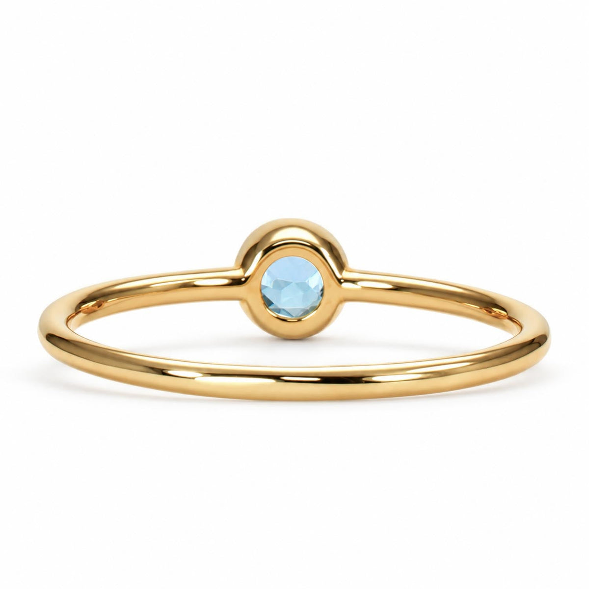 Side profile of the dainty aquamarine bezel ring in yellow gold