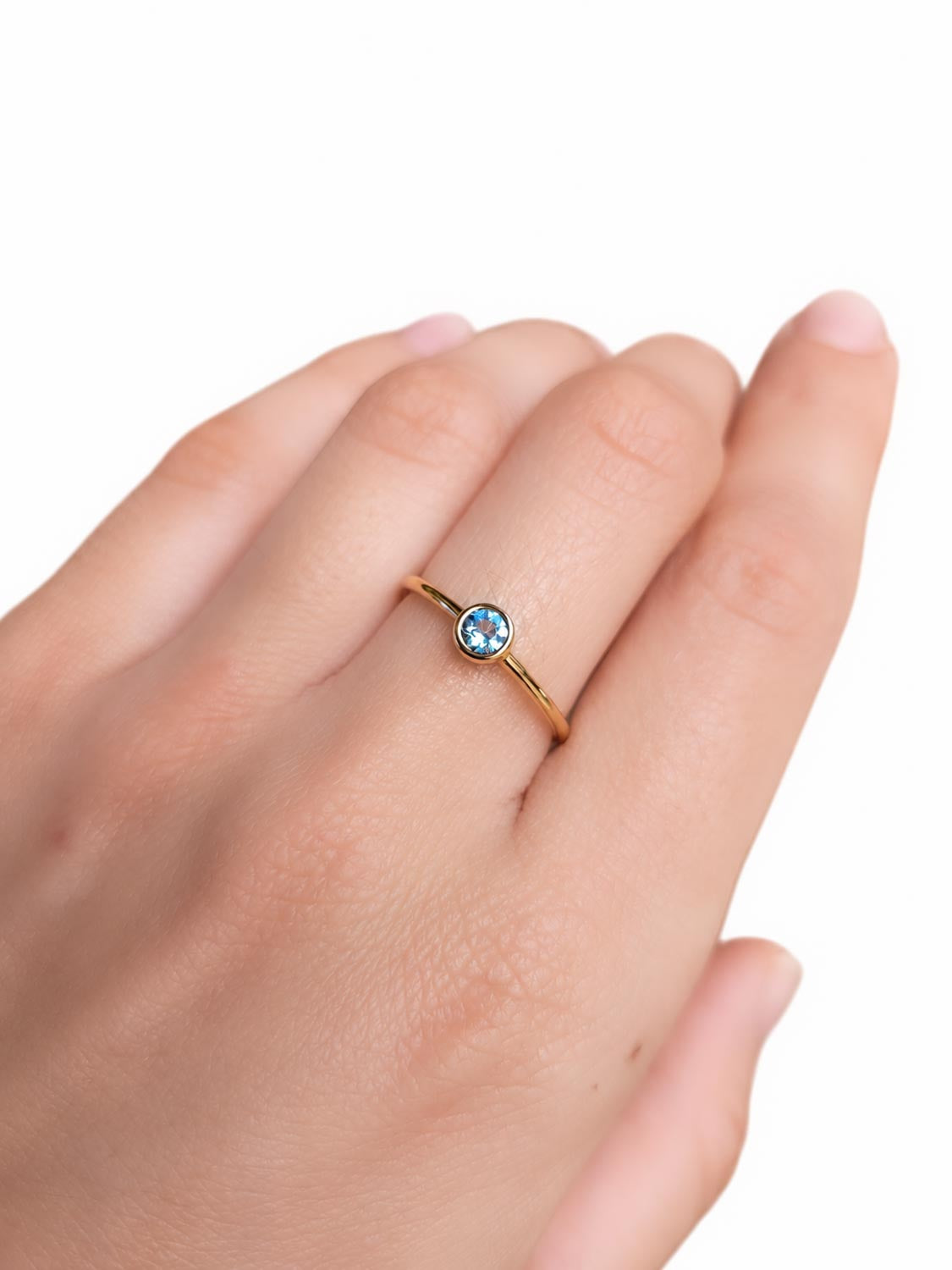 Close detail of the round aquamarine in its gold bezel setting