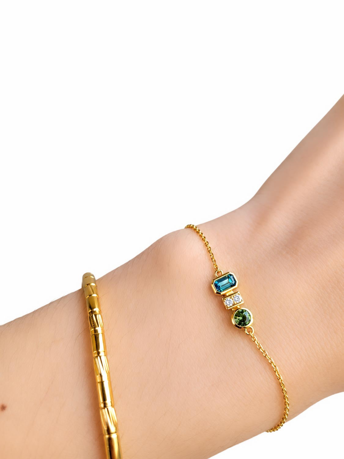 Close detail of the Australian teal sapphires and diamonds in 18K yellow gold