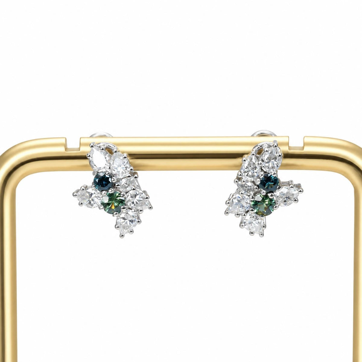 Pear cut teal sapphire and moissanite cluster earrings in sterling silver, angled view