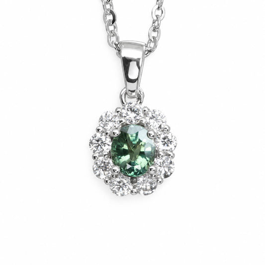 A platinum pendant necklace featuring a central alexandrite gemstone surrounded by a halo of diamonds, suspended from a silver chain on a white background.