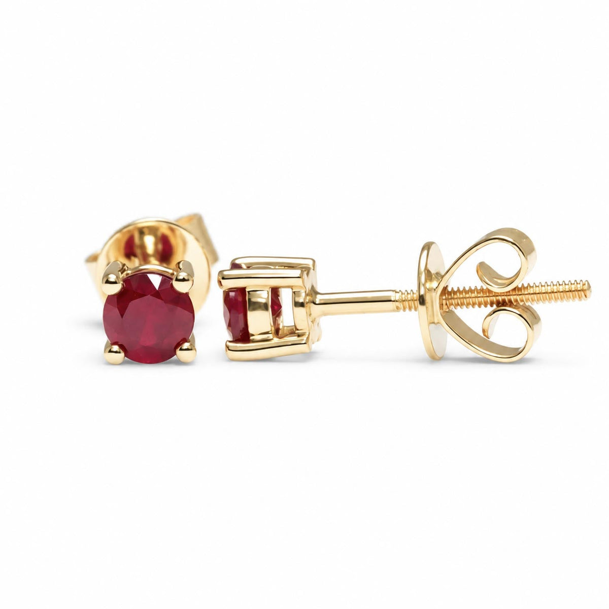 Four claw natural ruby studs in 18K yellow gold shown at an angle