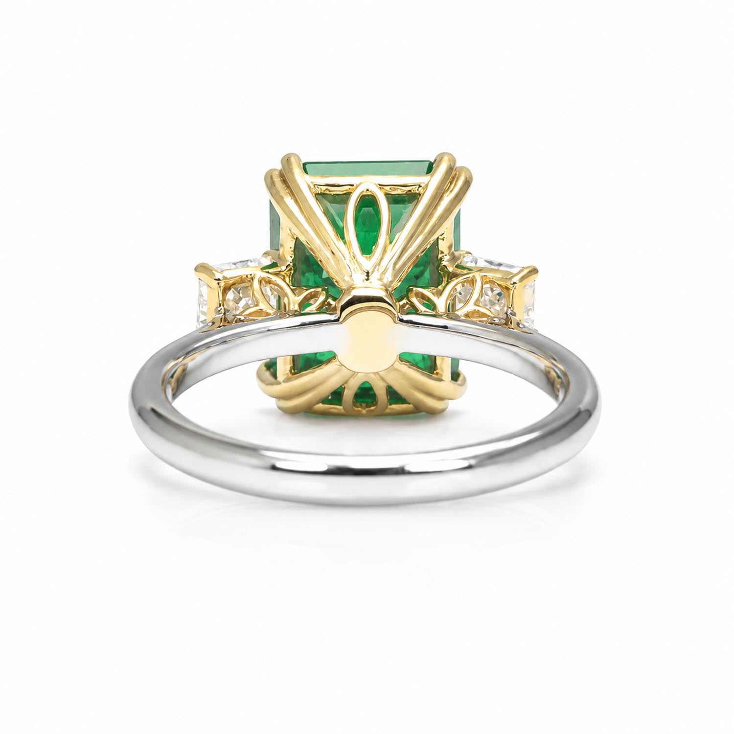 back view of a two-tone ring featuring a rectangular elemerald-cut Colombian emerald, yellow gold detailing, and a polished platinum band, shown on a white background