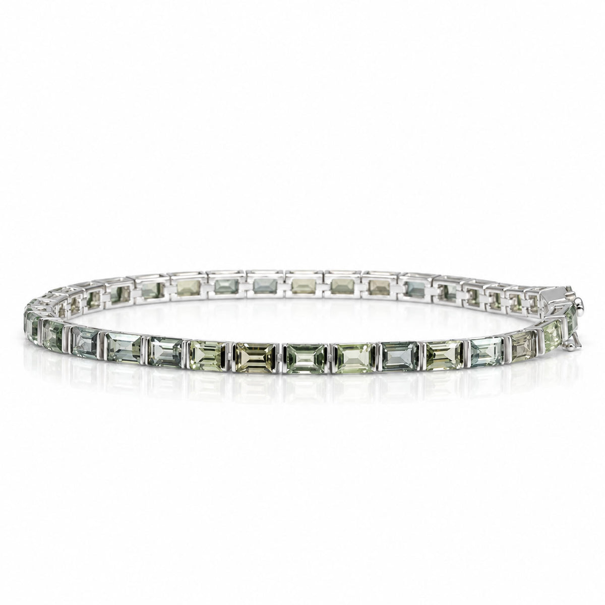 a platinum tennis bracelet with princess cut sapphires shown on a white background