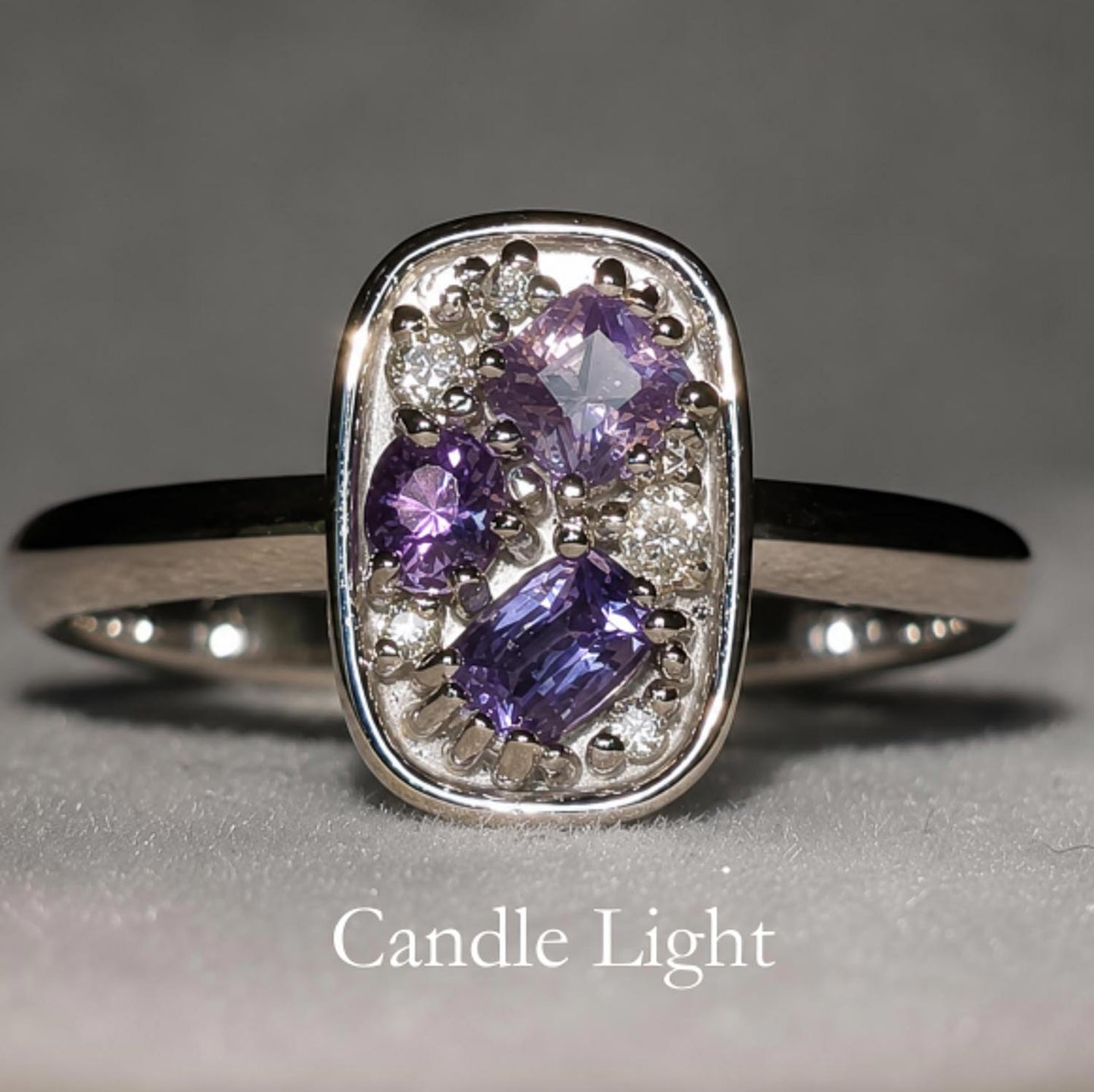 front view under incandescent light of Natural Alexandrite & Diamond Composition Ring in Platinum on gray background