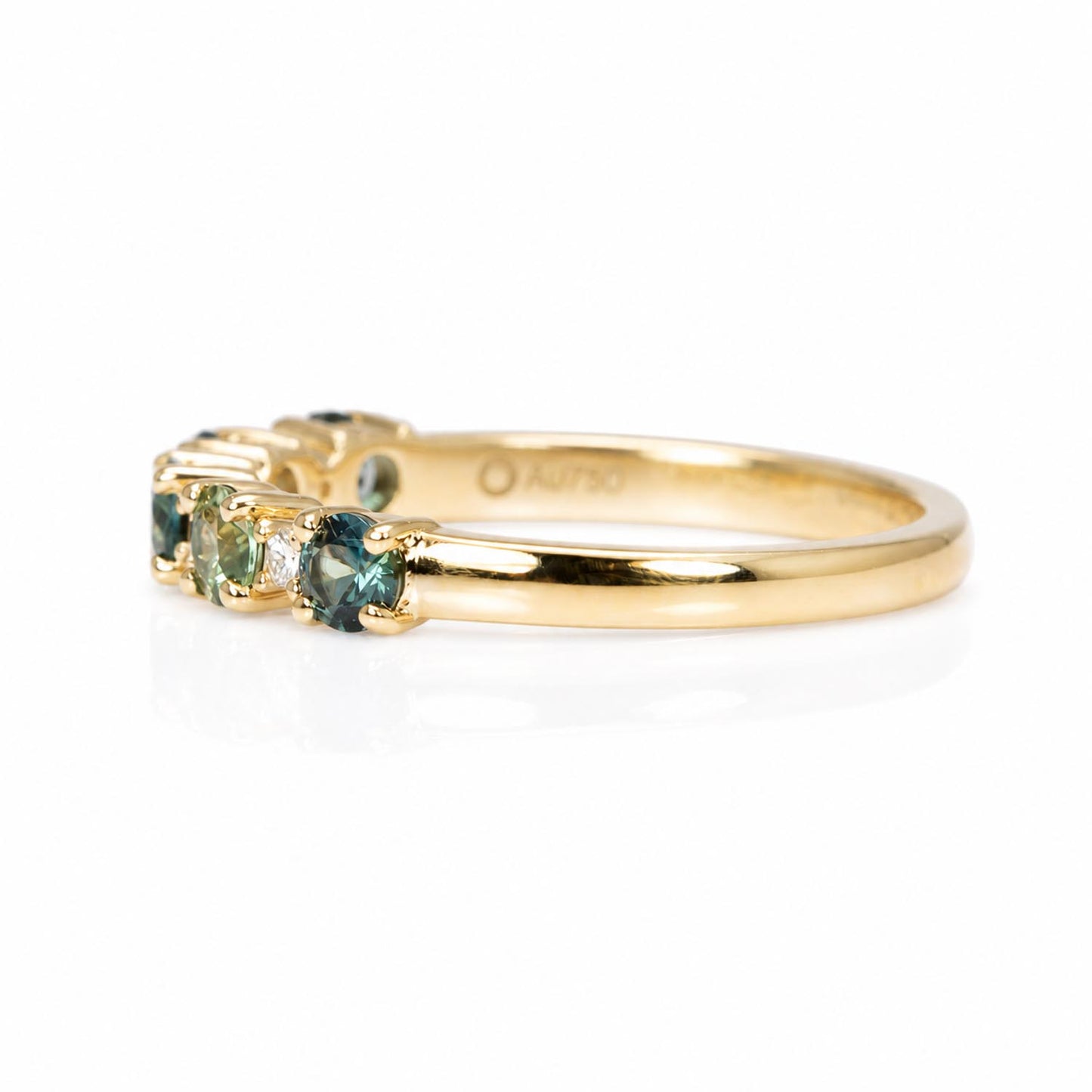 side view of a Australian Teal Sapphire & Diamond Band Ring in 18K Yellow gold in a white background