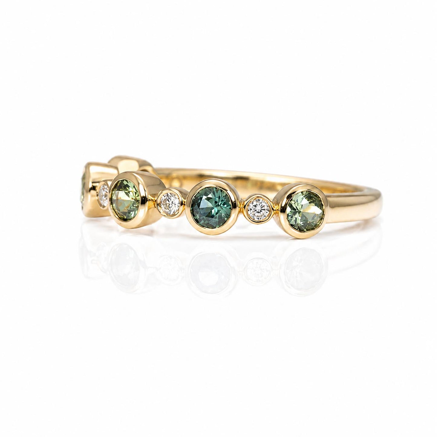 side view of a eternity band featuring five round Australian teal sapphires and five small diamonds accent stones, set against a clean white background with a soft reflection.