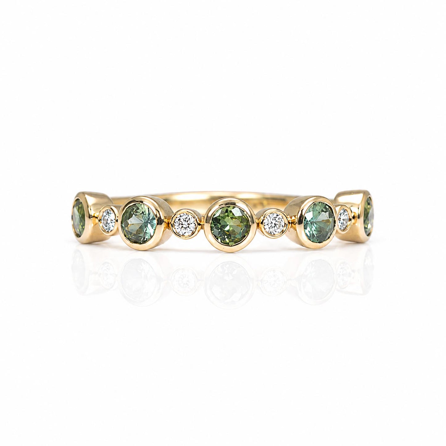A half eternity band featuring five round Australian teal sapphires and five small diamonds accent stones, set against a clean white background with a soft reflection.