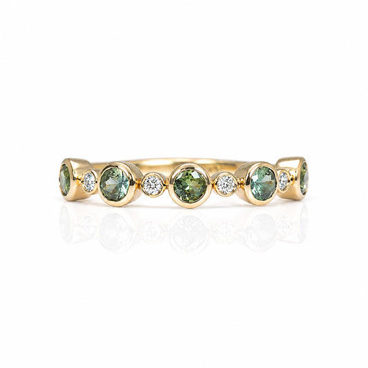 A half eternity band featuring five round Australian teal sapphires and five small diamonds accent stones, set against a clean white background with a soft reflection.