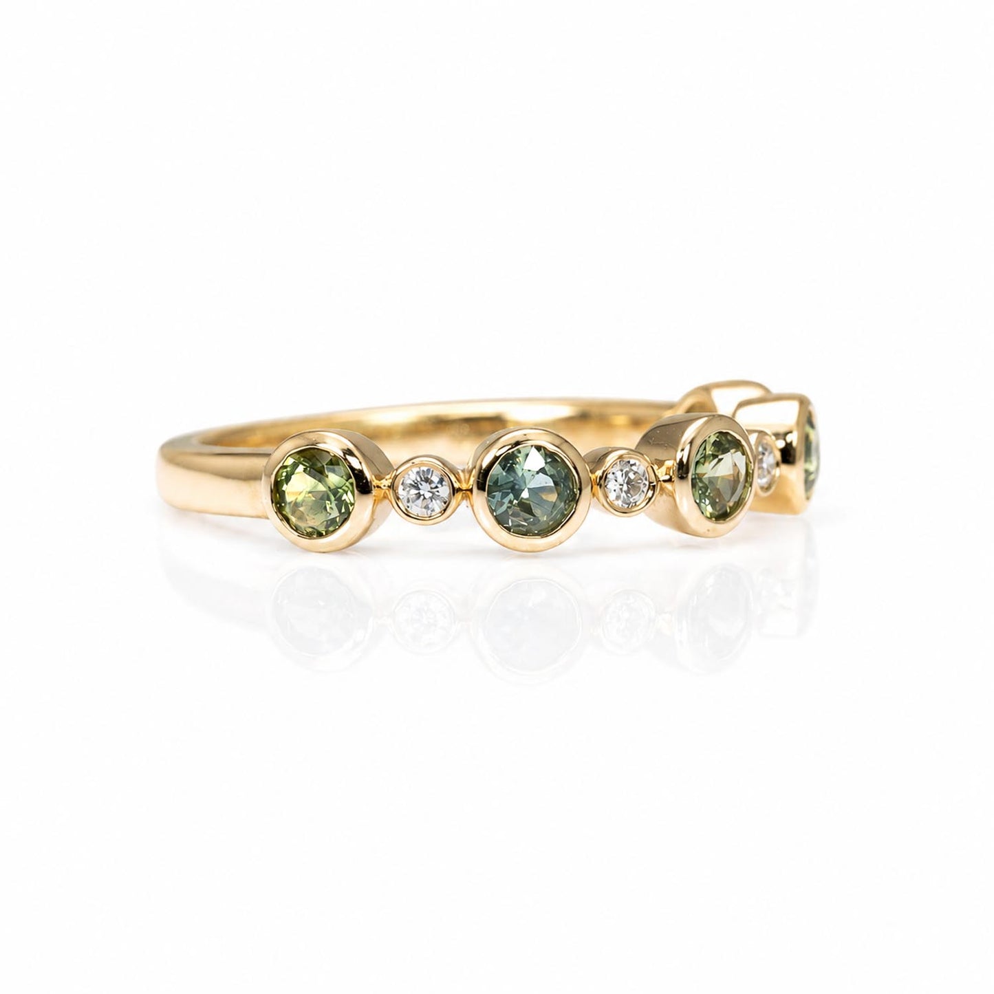 close-up side view of a eternity band featuring five round Australian teal sapphires and five small diamonds accent stones, set against a clean white background with a soft reflection.