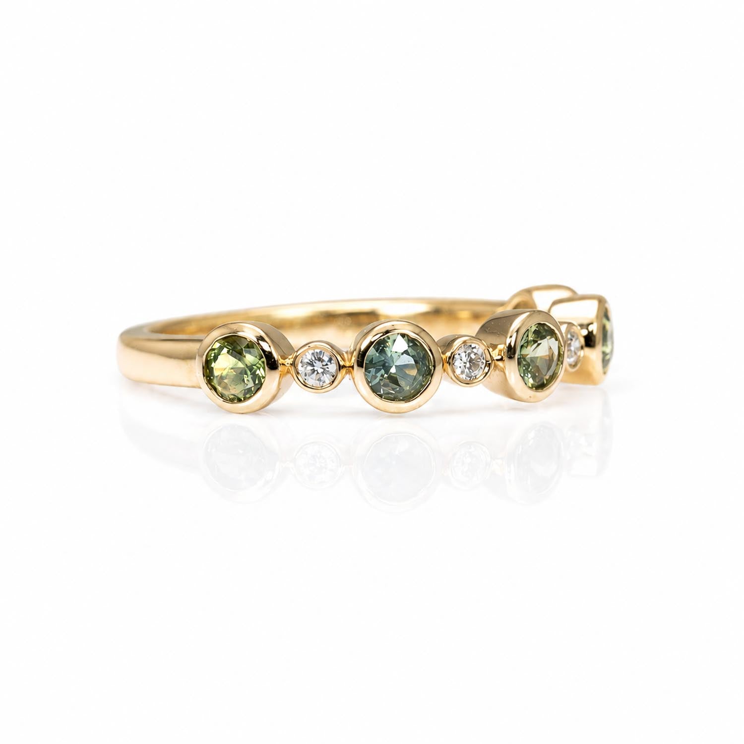 close-up side view of a eternity band featuring five round Australian teal sapphires and five small diamonds accent stones, set against a clean white background with a soft reflection.