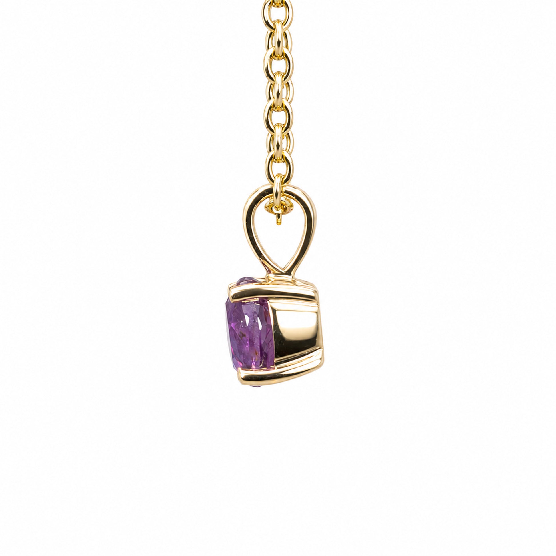 A gold pendant necklace featuring a small oval pink sapphire in a polished gold setting, suspended from a gold chain against a plain white background.