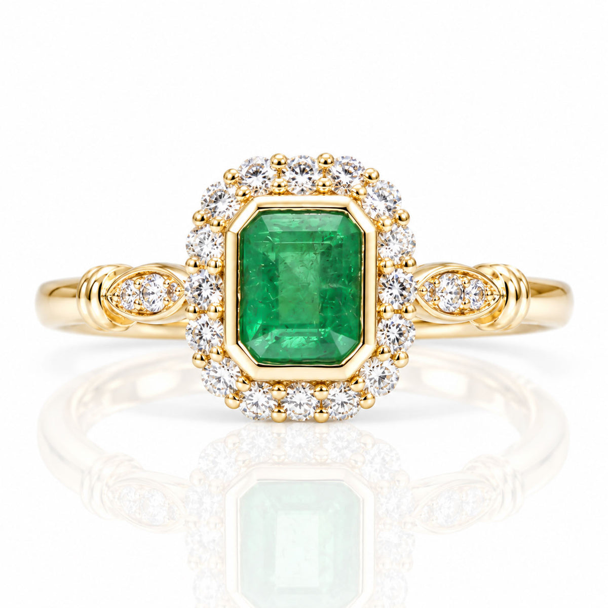 A yellow gold ring featuring a large emerald-cut Colombian emerald in a halo setting surrounded by small round diamonds, with additional diamonds on the band, shown on a reflective white background