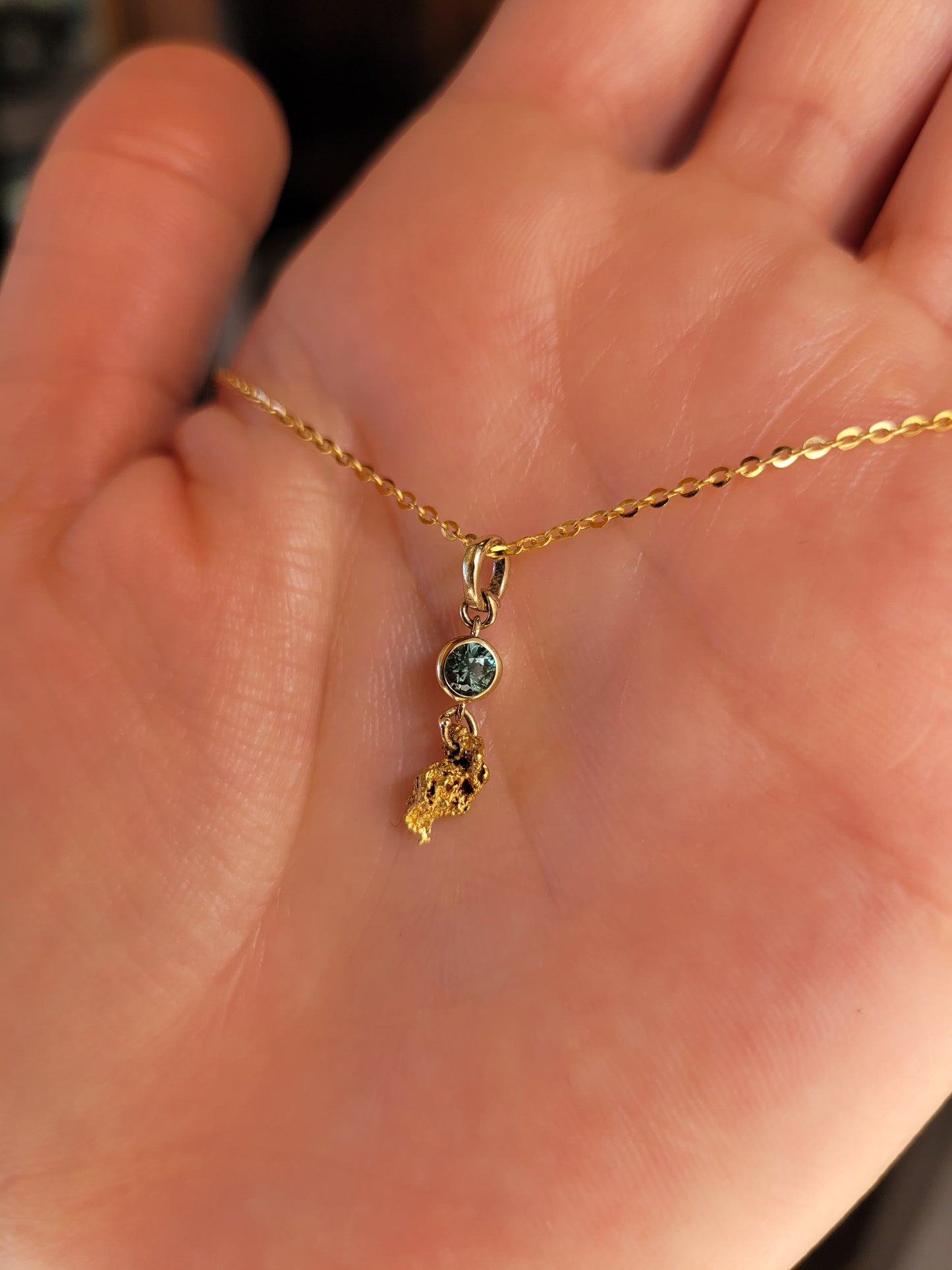 photo on hand of second sapphire and gold nugget pendant