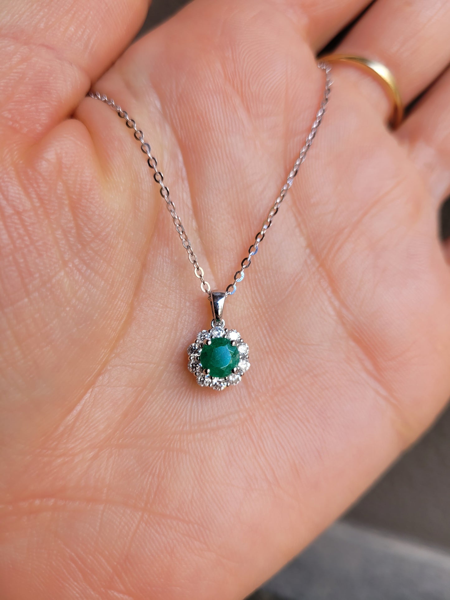 Colombian emerald pendant on a hand
