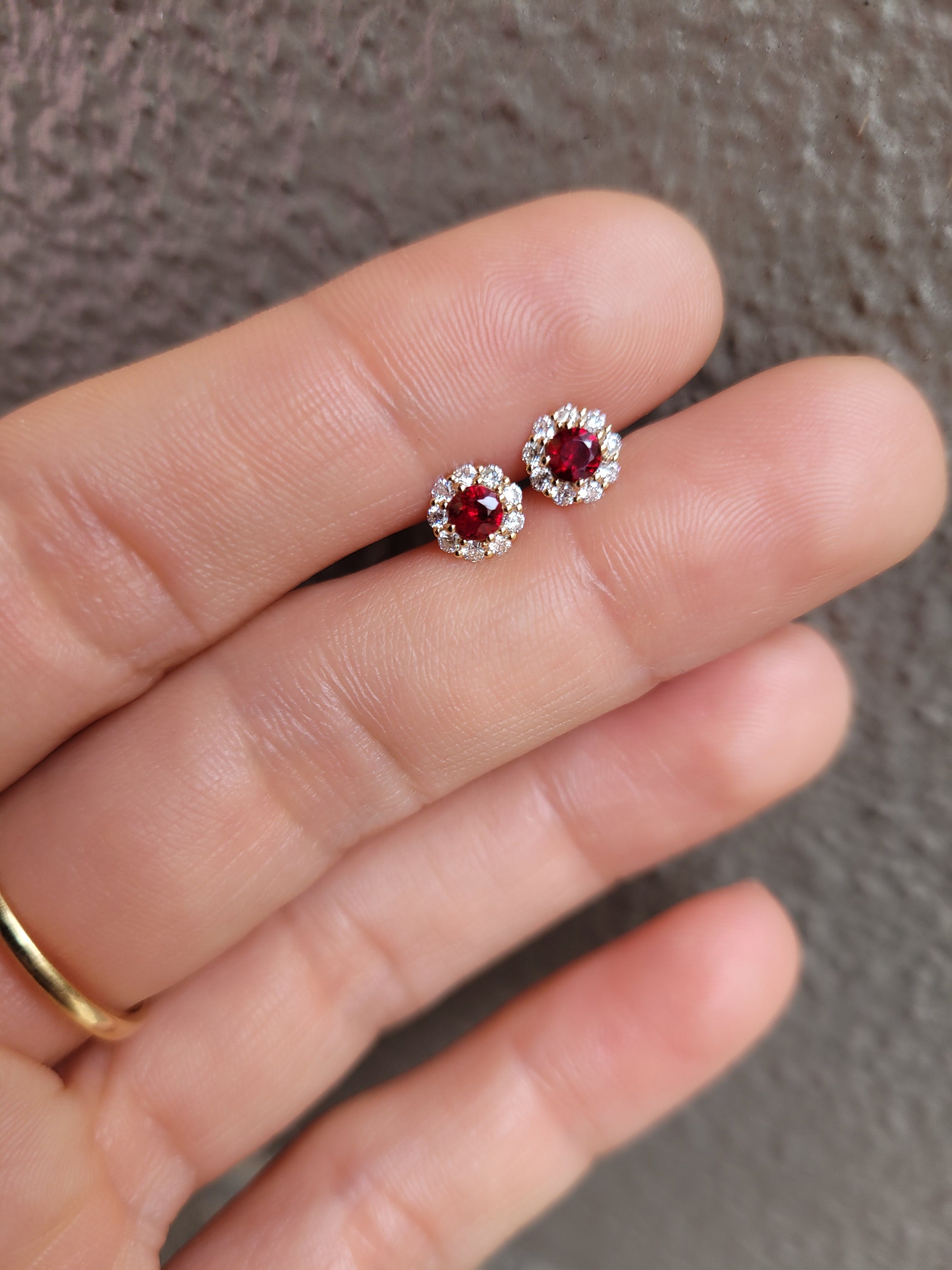 photo of ruby studs held on a hand