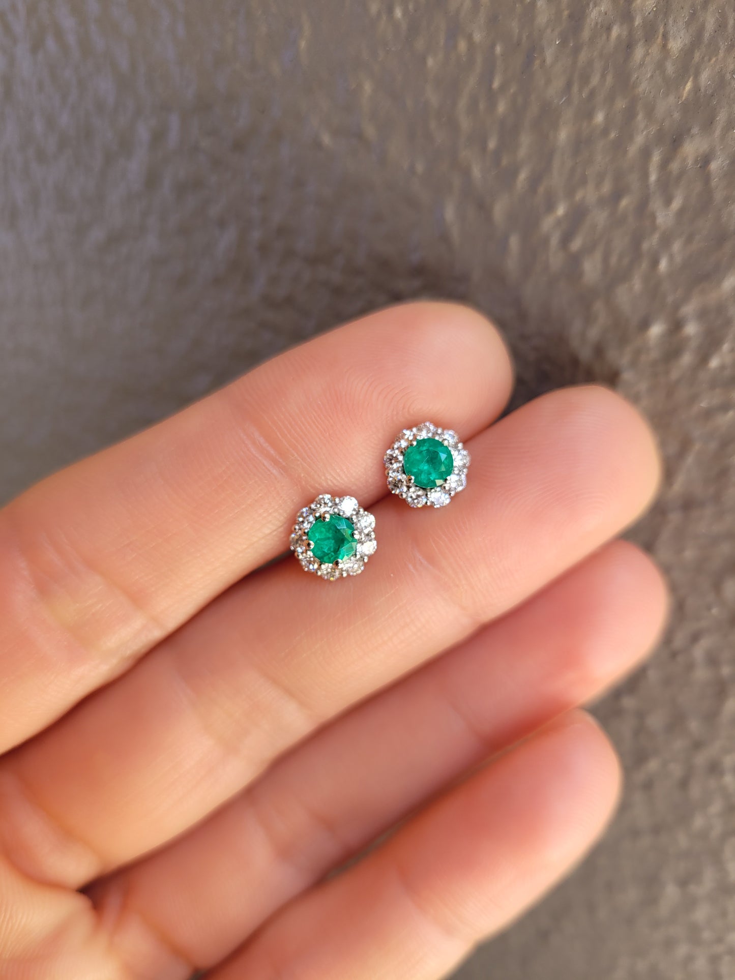 front view of Colombian Emerald earrings held in hand
