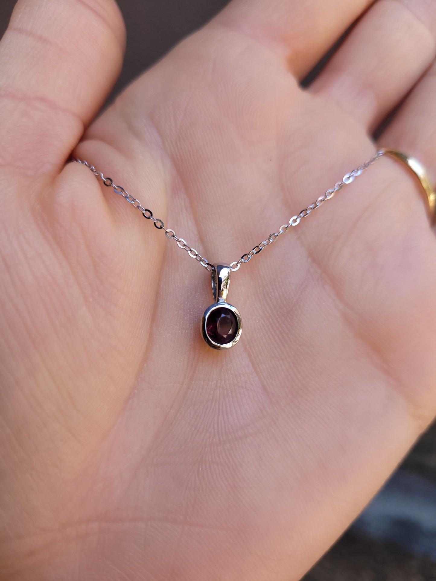 Platinum pendant with natural ruby shown on a hand