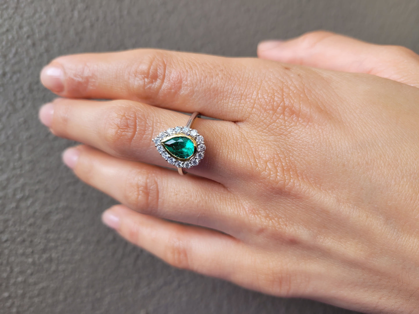 Hand wearing a Colombian Pear Emerald Halo Ring 1.17ct in 18K White & Yellow Gold 