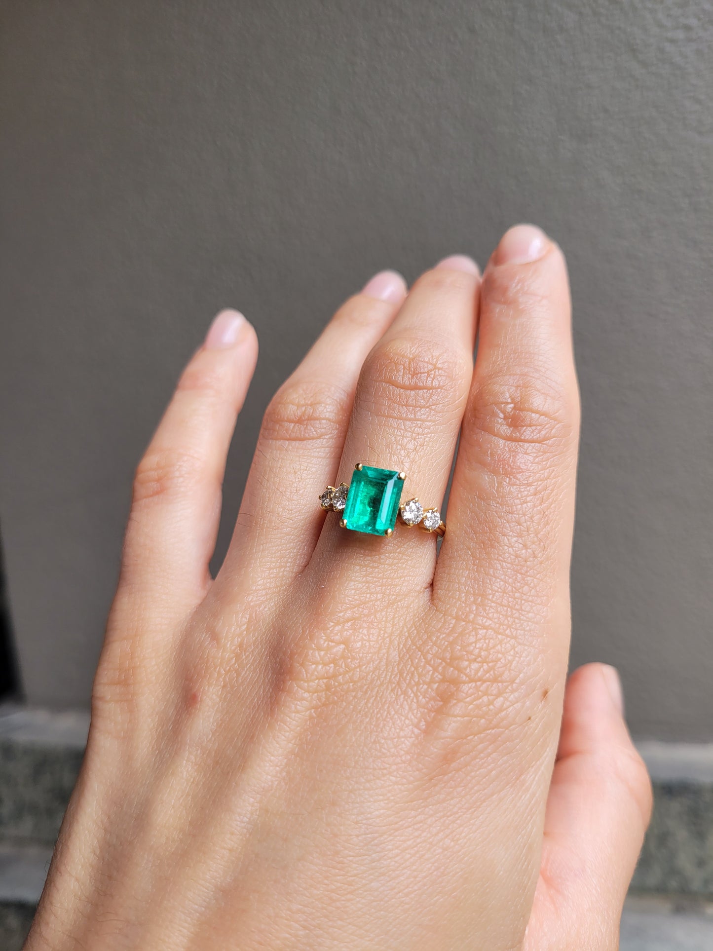 Hand wearing a 2.29ct Natural Colombian Emerald Ring with GIA Diamonds 