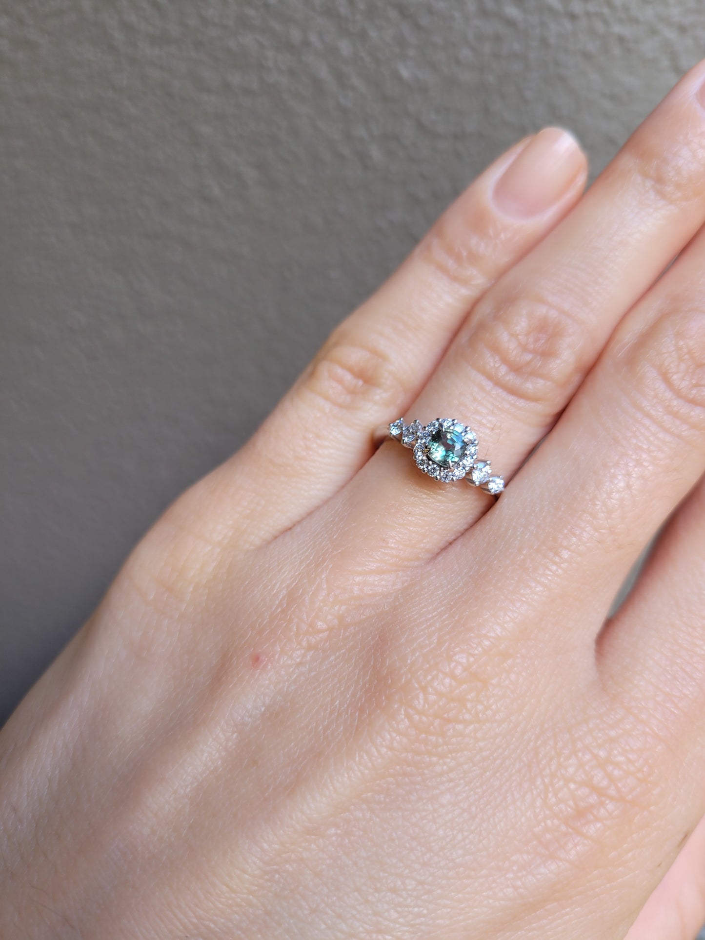 view view on hand of Natural Alexandrite and Diamond Halo Ring in 18K Yellow Gold in neutral background