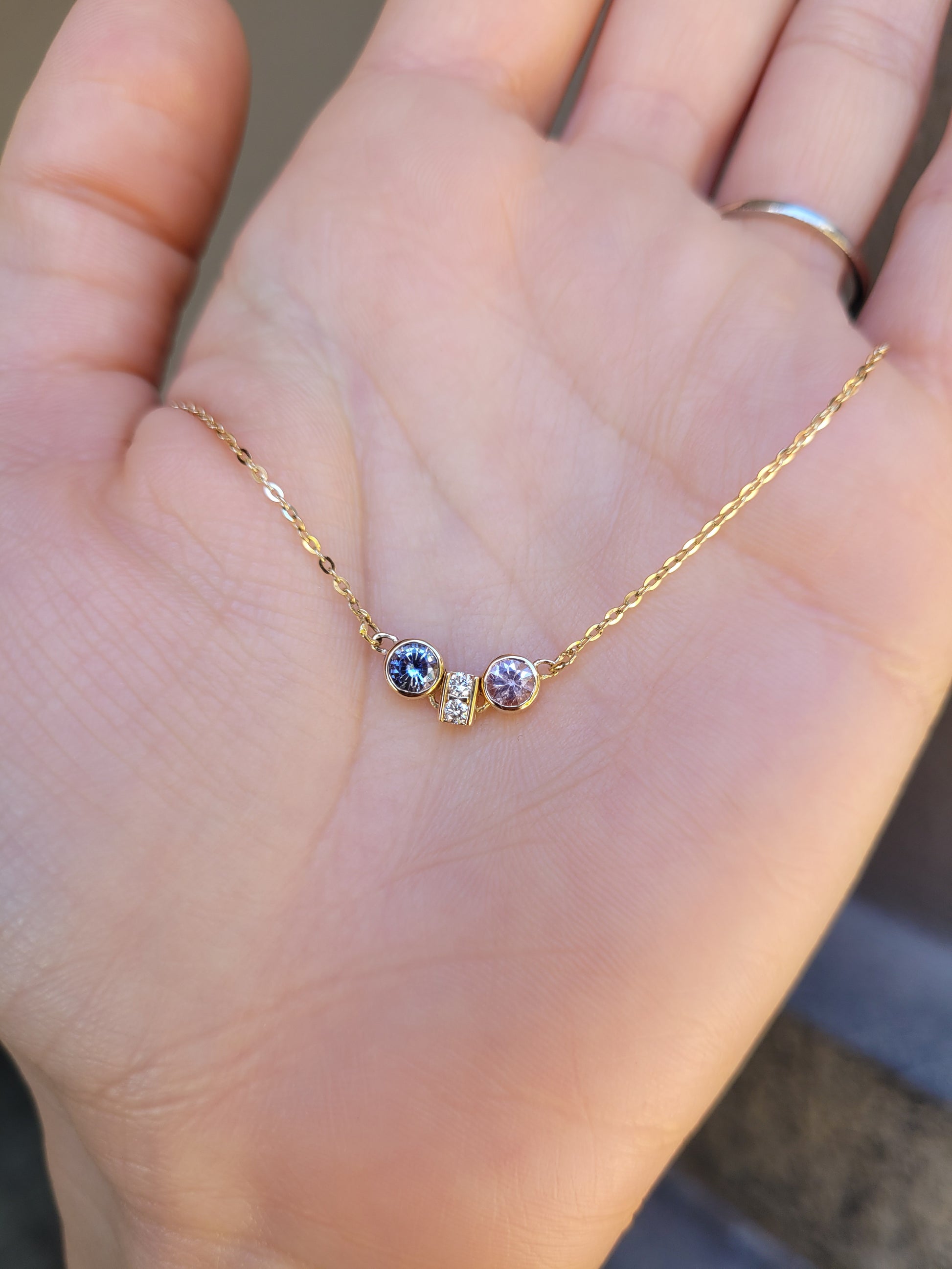 front view of Pink Sapphire & Purple Blue Sapphire Diamond Pendant in 18K Yellow Gold held on hand
