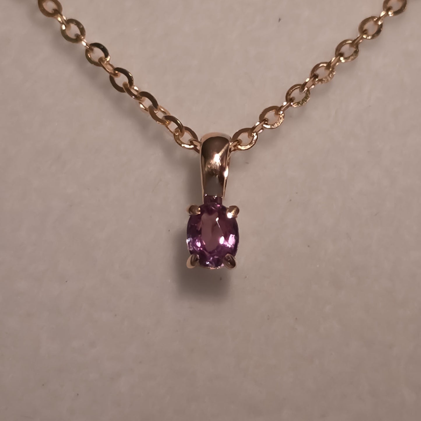 front view under incandescent light of Petite Oval Alexandrite Pendant in 18K Yellow Gold – 0.16ct 