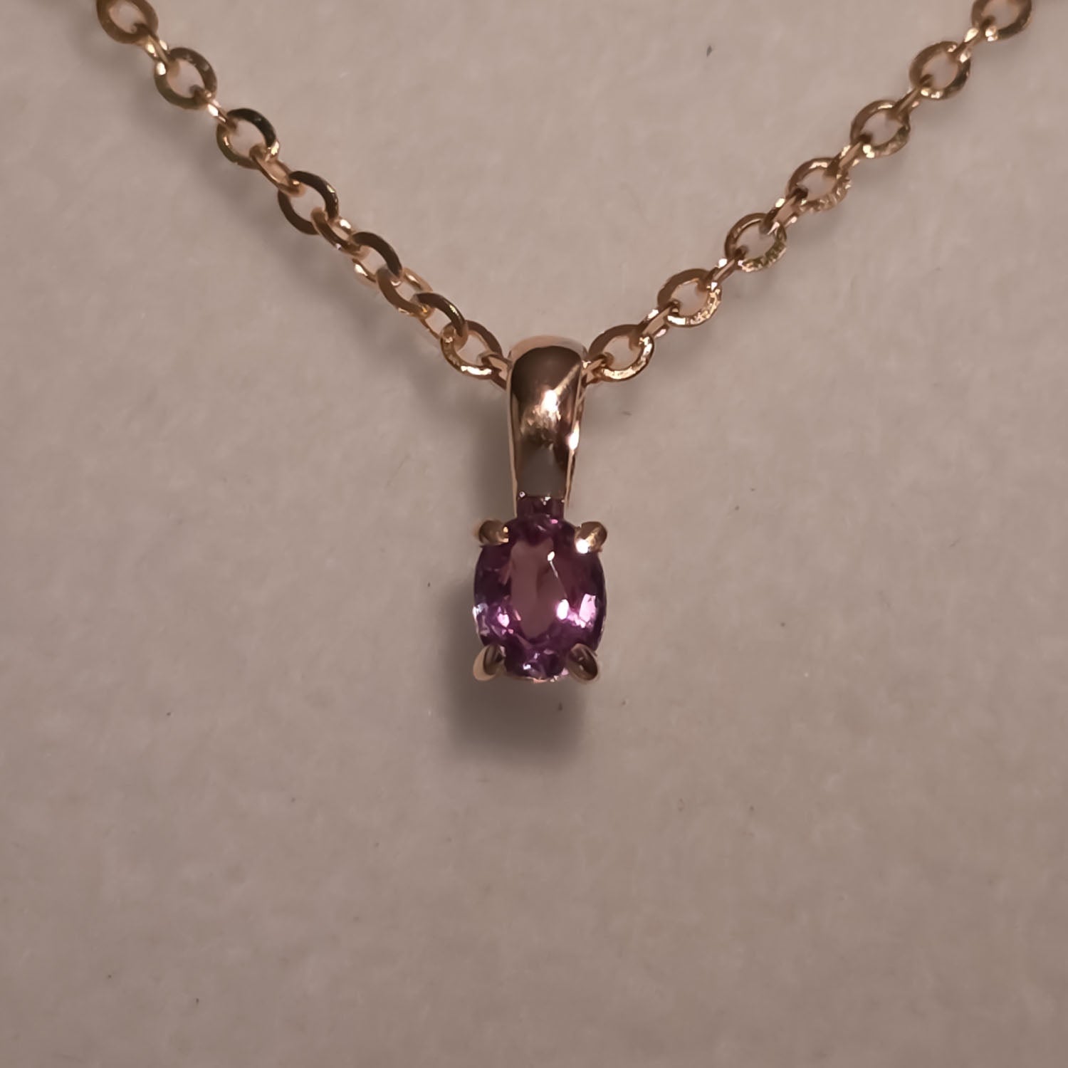 front view under incandescent light of Petite Oval Alexandrite Pendant in 18K Yellow Gold – 0.16ct 