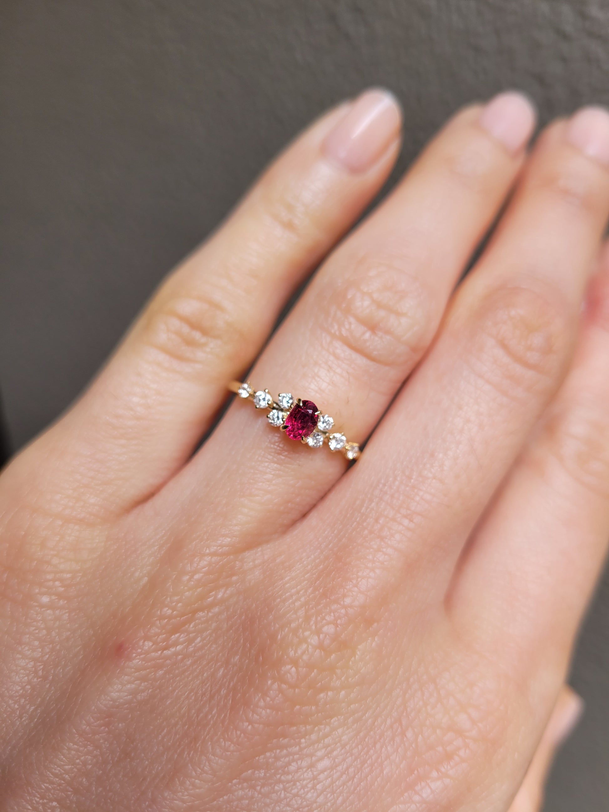 view of a Natural Ruby & Diamond Ring in 18K Yellow Gold worn on a hand in neutral background