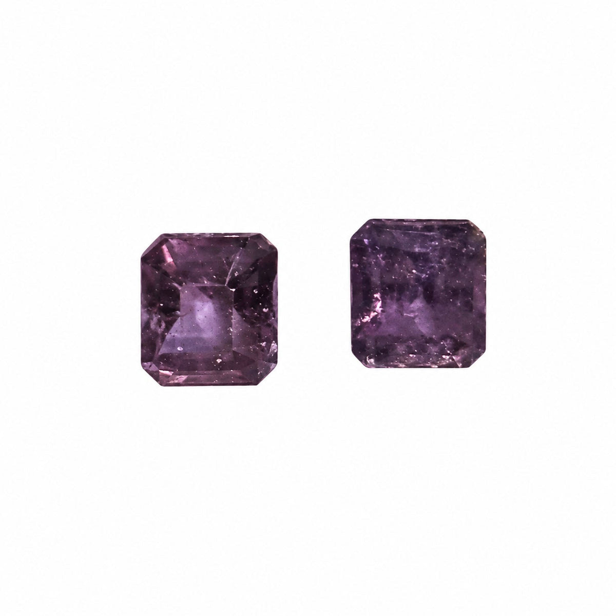 0.96 ct alexandrite pair under warm light showing their colour change