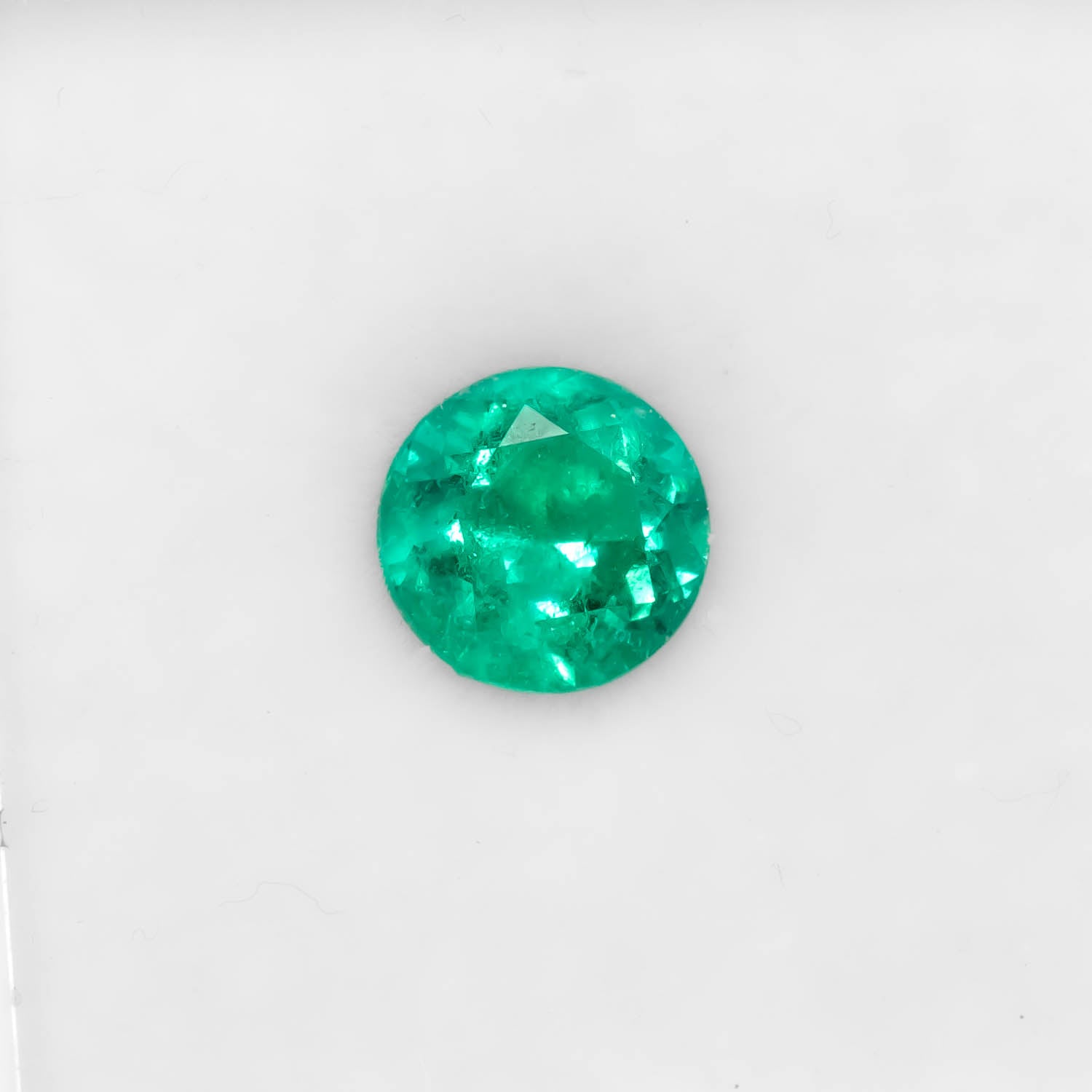 Front view of 0.81CT Natural Colombian Emerald – Round Cut Strong Green Gemstone in white brackground.