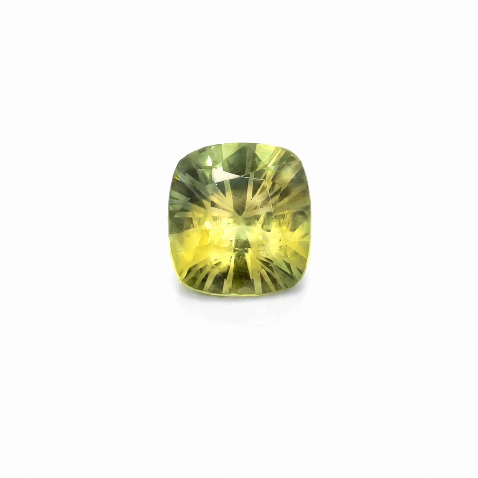 A cushion-cut yellow-green natural sapphire with a faceted starburst pattern, centered on a plain white background.