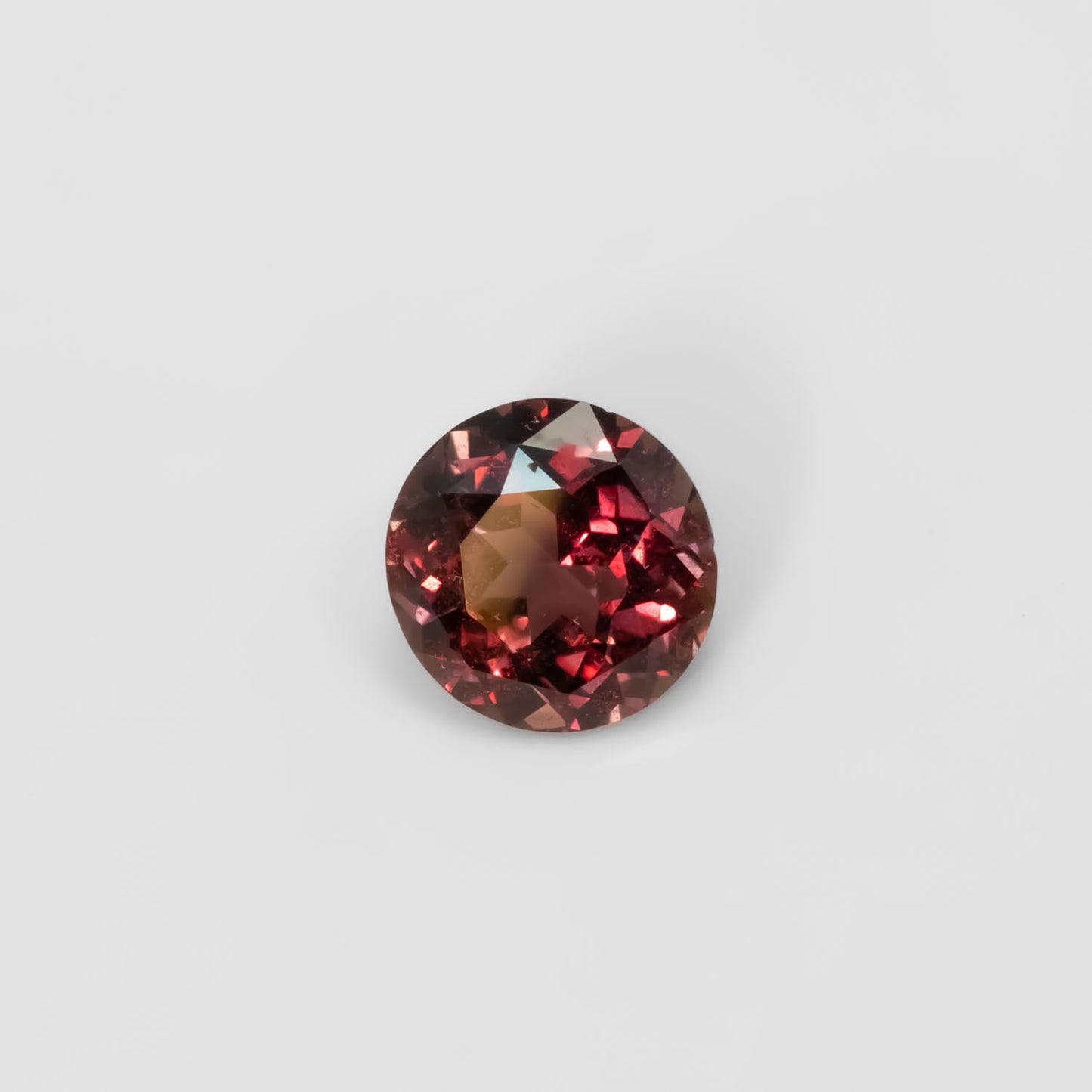 Front view of 1.89CT Natural Unheated Colour Change Brown-Red Sapphire – Round Mixed Cut in white background.