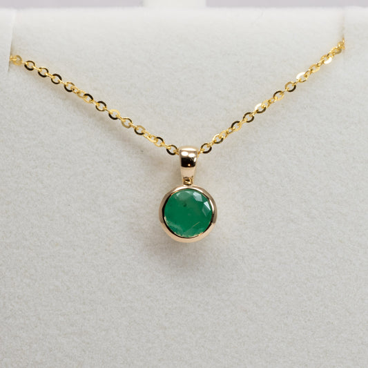 front view of Round Colombian Emerald Bezel Set Pendant in 18K Yellow Gold – 0.62ct in white background