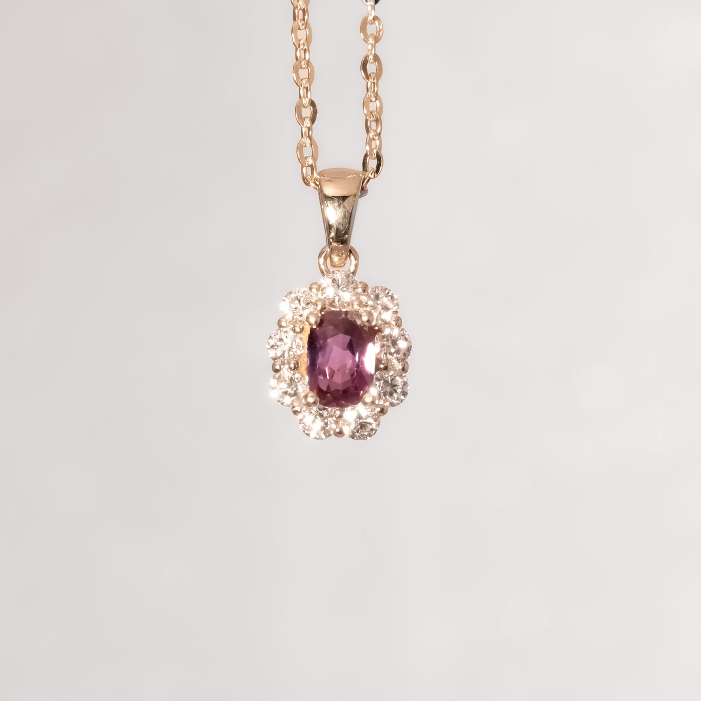front view under incandescent light of Natural Alexandrite Halo Pendant 0.34ct Oval Cut in 18K Yellow Gold in neutral background
