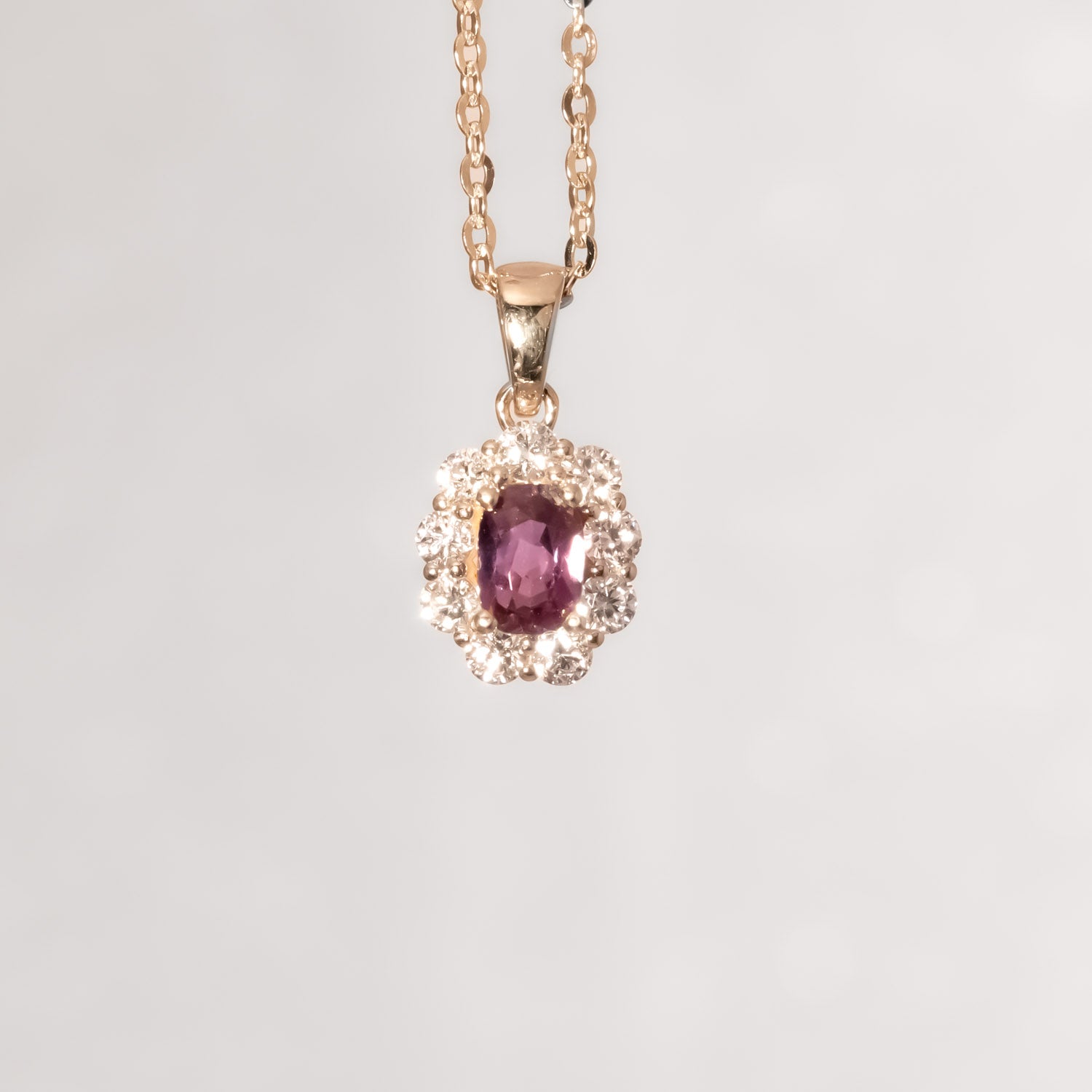 front view under incandescent light of Natural Alexandrite Halo Pendant 0.34ct Oval Cut in 18K Yellow Gold in neutral background
