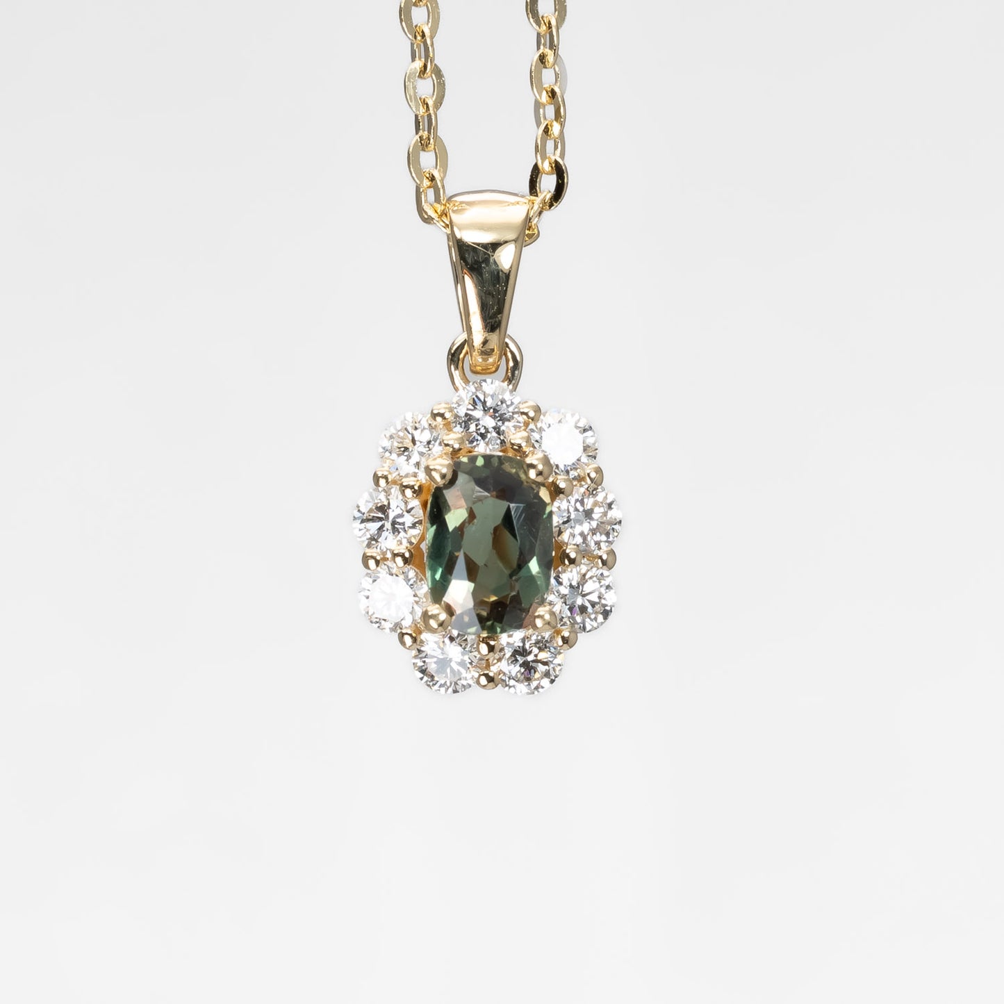 front view of Natural Alexandrite Halo Pendant 0.34ct Oval Cut in 18K Yellow Gold in neutral background