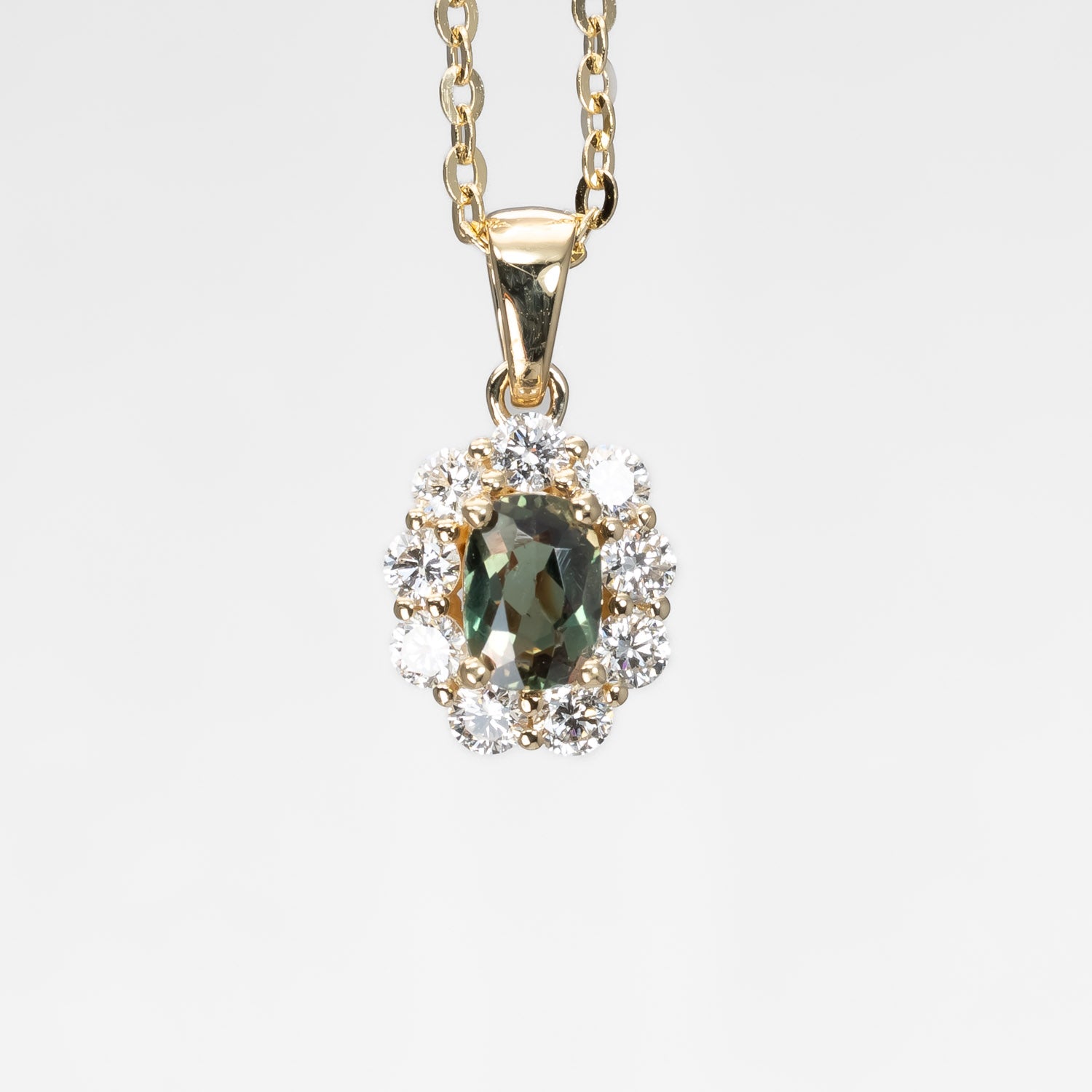front view of Natural Alexandrite Halo Pendant 0.34ct Oval Cut in 18K Yellow Gold in neutral background