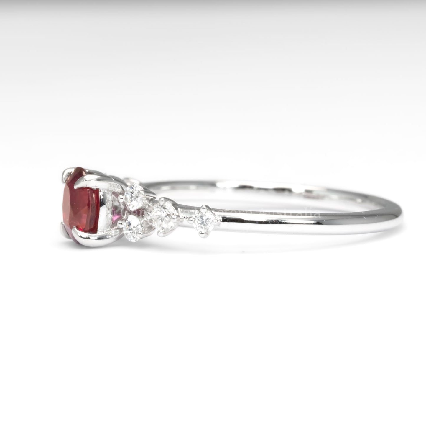 side view of natural ruby and diamond ring in platinum 950 in white background
